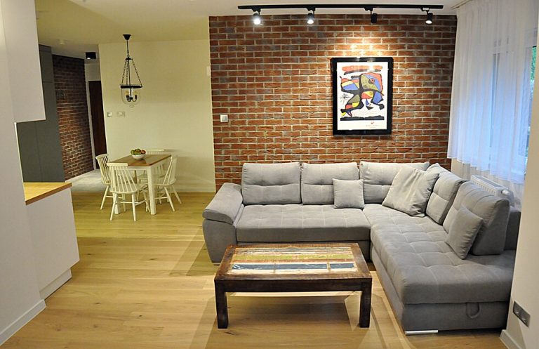 dekoracja w salonie - cegły na ścianie, panele podłogowe