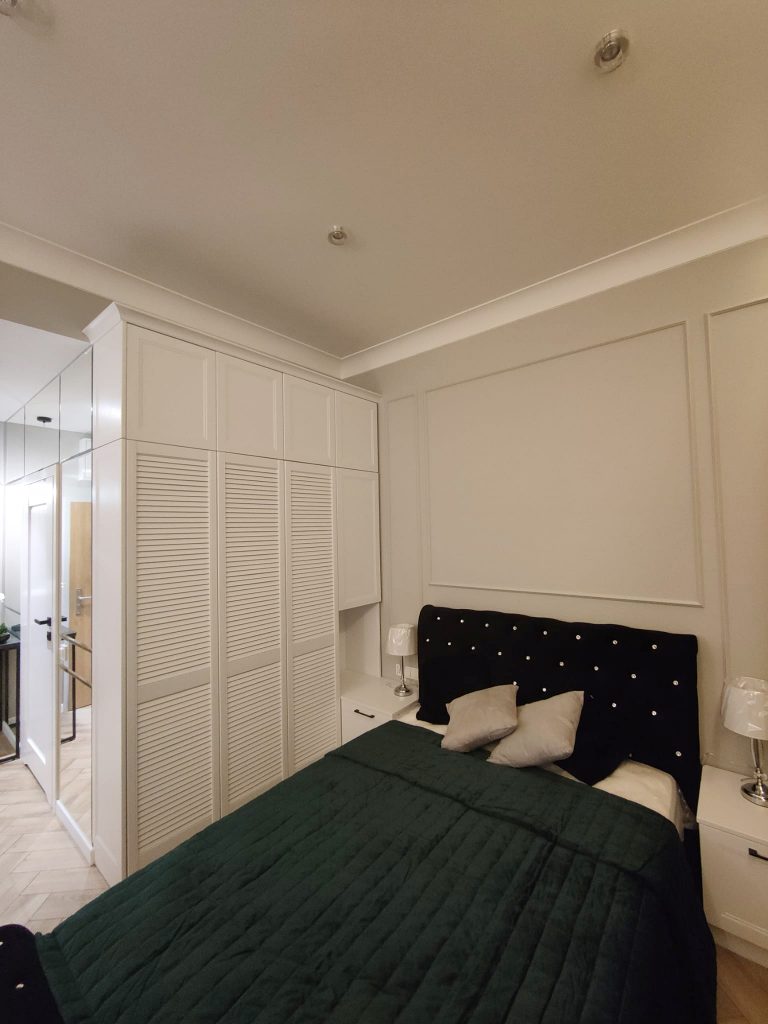 zabudowa wnęki w sypialni, biała szafa, podwieszany sufit, sztukateria