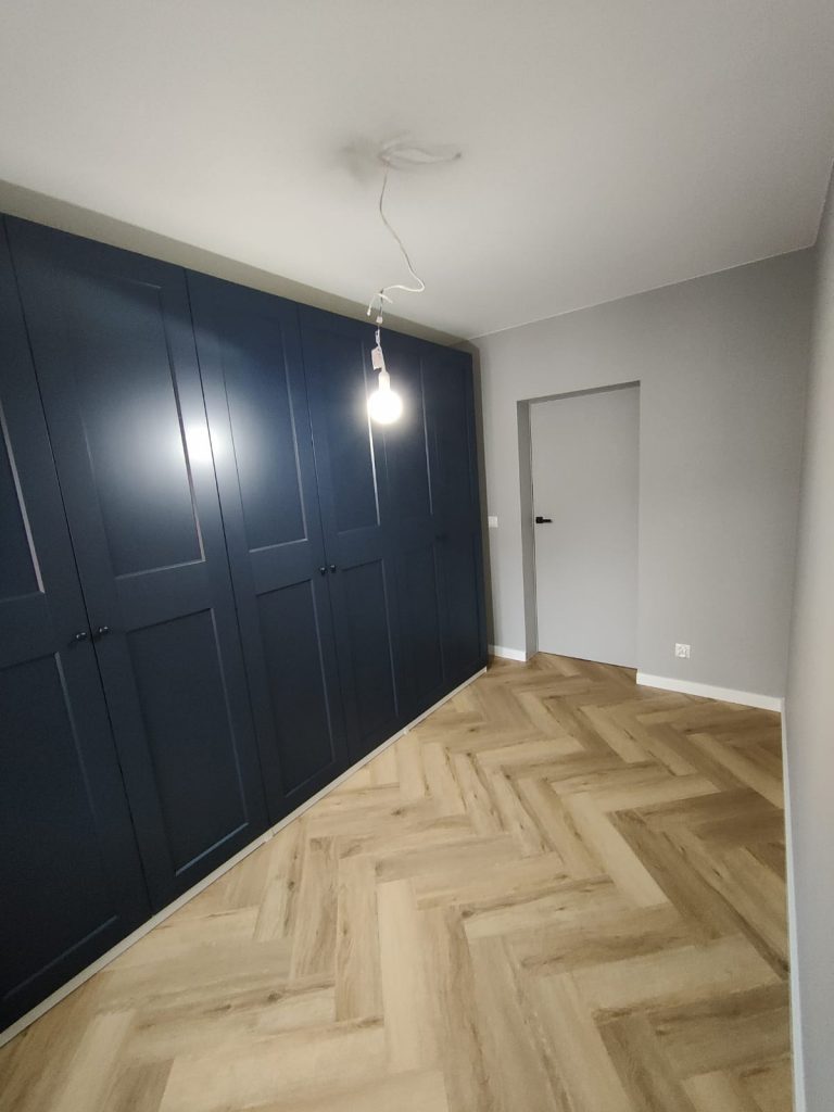 układanie podłogi w jodełkę, szare drzwi, zabudowa szafy