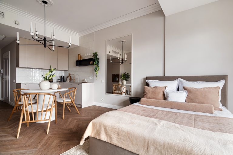 nowoczesna kawalerka, łóżko sypialne w aneksie, podłoga w jodełkę, sztukateria, wykończenie wnętrza