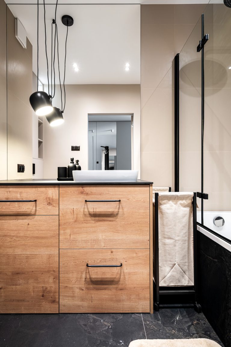 jasna łazienka z wbudowanym lustrem i czarnymi dodatkami